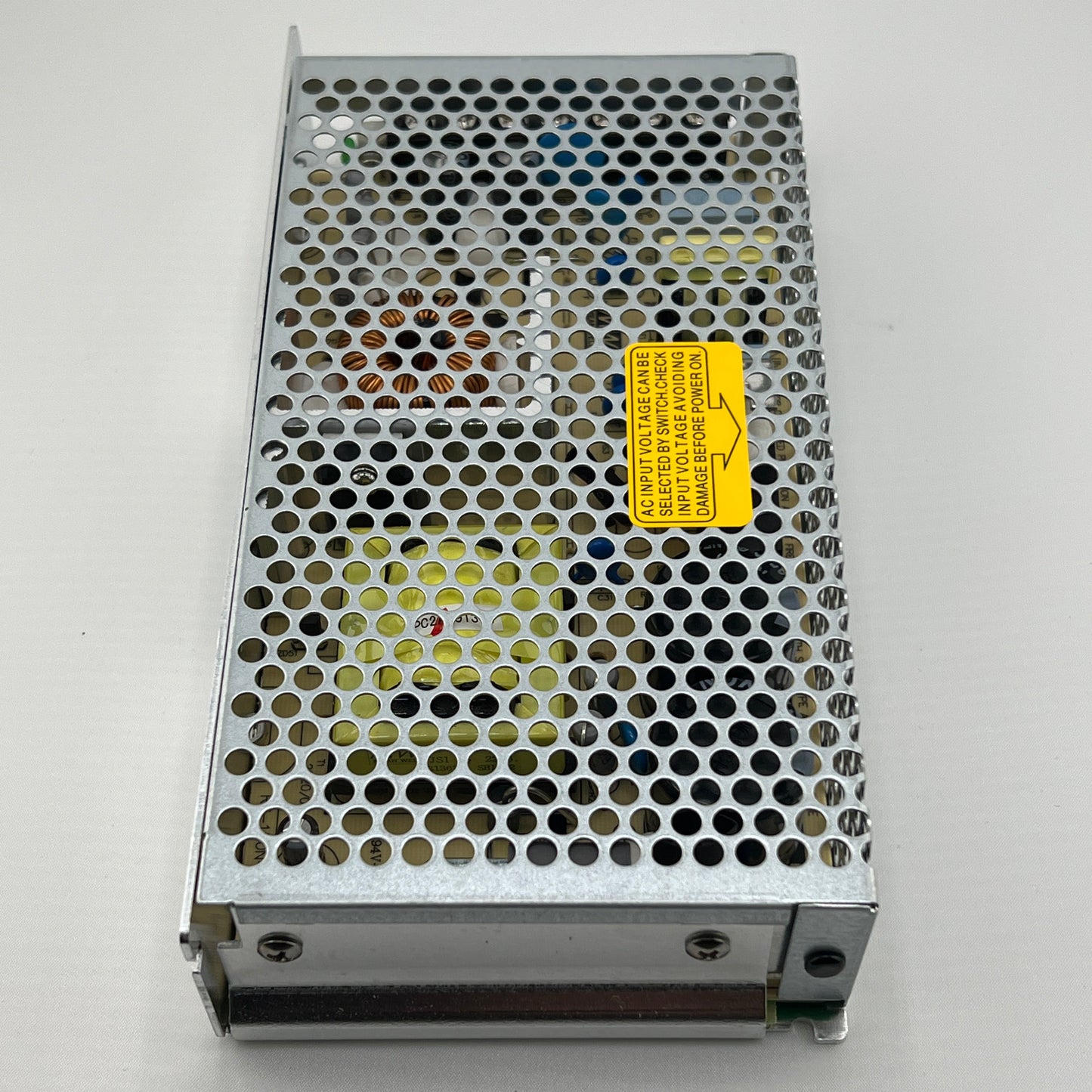 Metallic power supply unit with a yellow label on a gray background